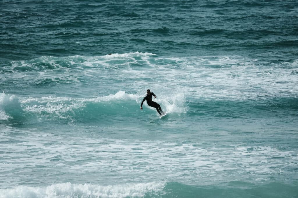 Best beaches in Cornwall - surfing a wave in the sear at Fistral in Newquay